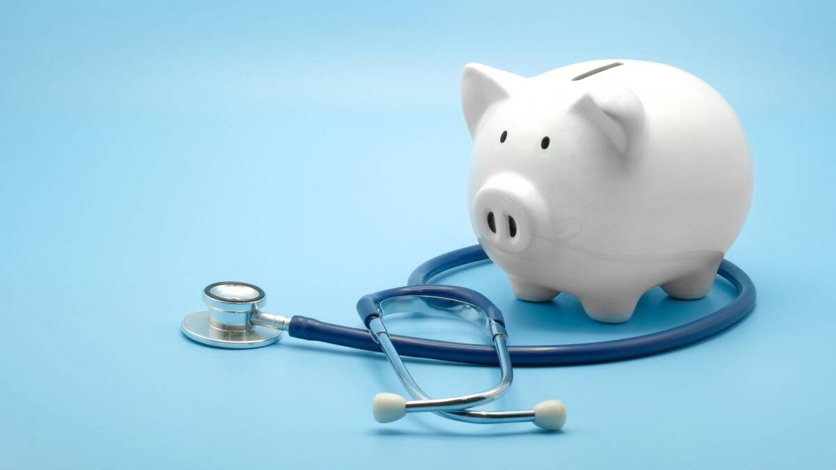 Piggy bank with stethoscope isolated on light blue background with copy space